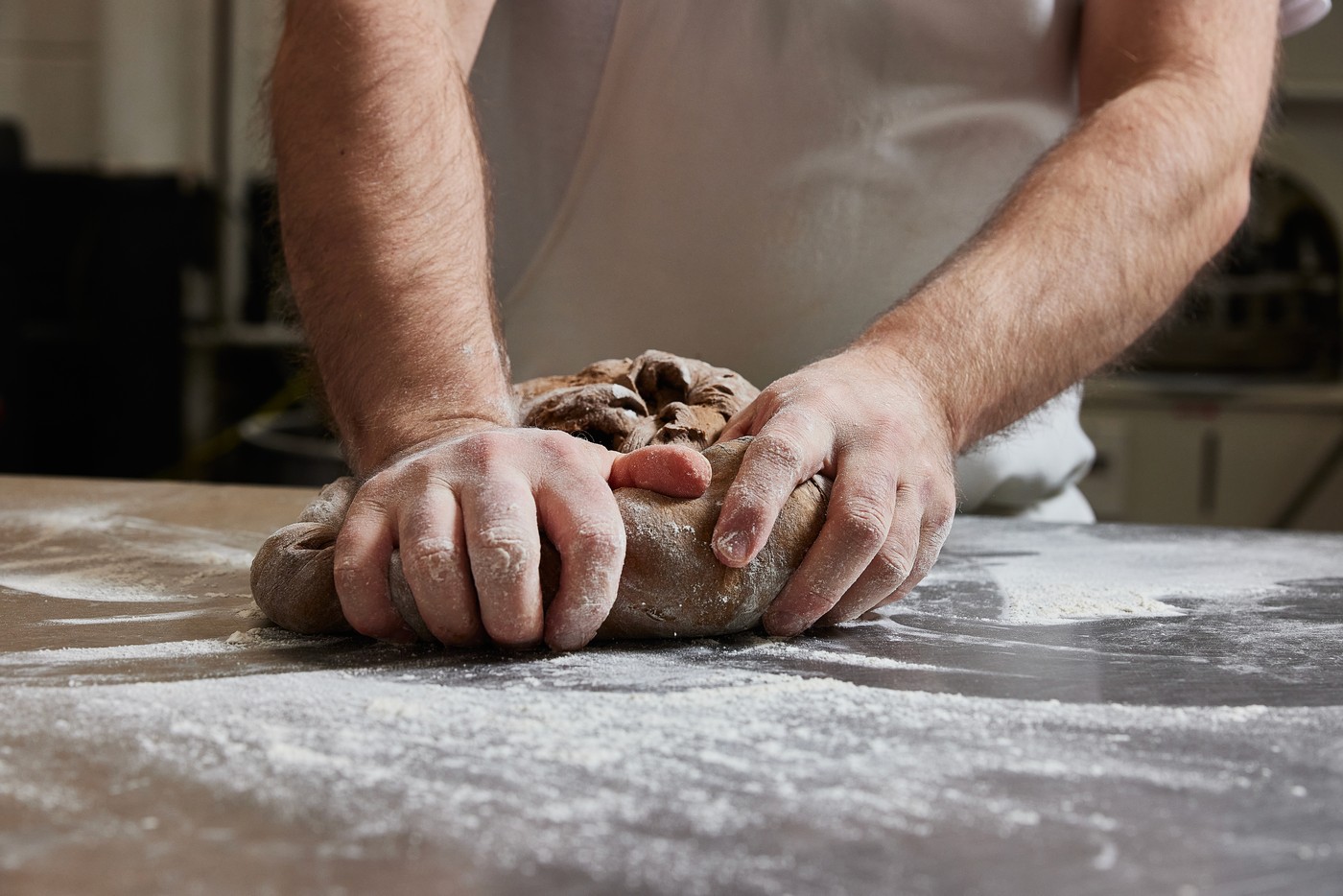 A baker shaping dough by hand